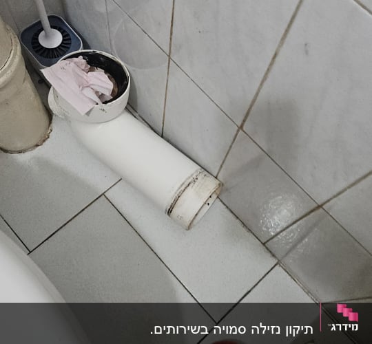 צינור ביוב עם מברשת ניקוי ובד אדום על הרצפה